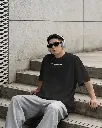 printful-tshirt-mockup-male-model-sitting-on-urban-steps-wearing-headphones-in-streetwear-style-04067.webp